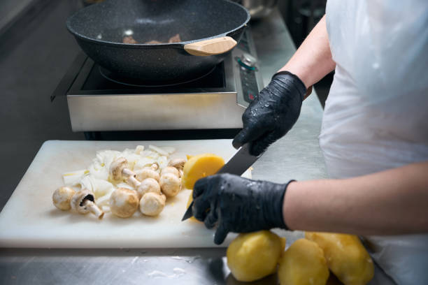istock Female worker cuts vegetables and mushrooms on a cutting board 2159225038