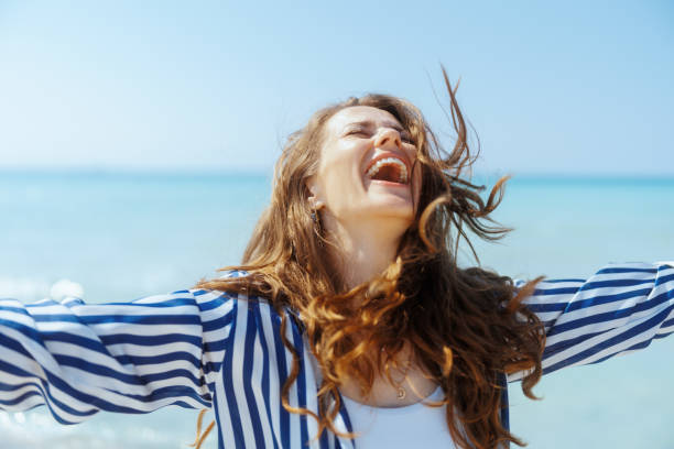 istock smiling modern woman on seashore having fun time 2159227588