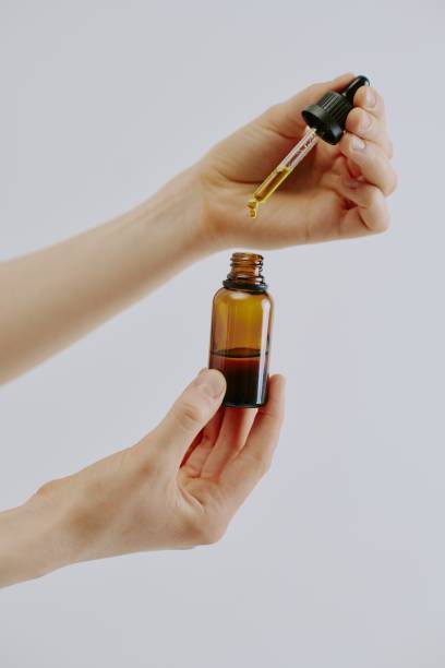 istock Woman Holding Bottle with Golden Essence 2159232850