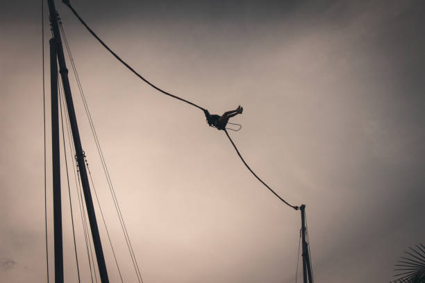 Young woman climbing up after bungee jumping