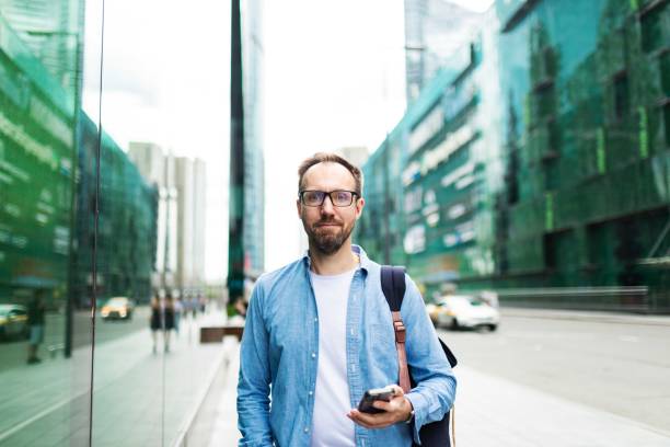 istock Mid adult man using mobile at the street 2159234979