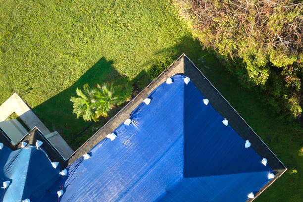 istock Hurricane Ian damaged house rooftop covered with protective plastic tarp against rain water leaking until replacement of asphalt shingles. Aftermath of natural disaster 2159234988