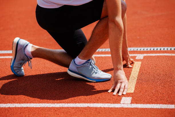 istock A track runner is standing at the starting line, getting ready for a quick sprint 2159236507