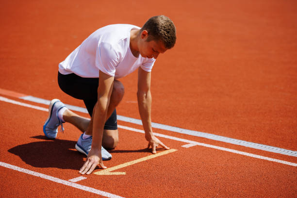 istock A track runner is standing at the starting line, getting ready for a quick sprint 2159236945