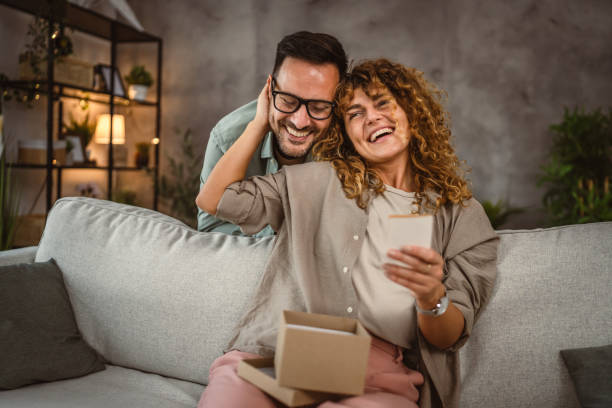 istock Surprised girlfriend hold gift read greeting card from her boyfriend 2159238073