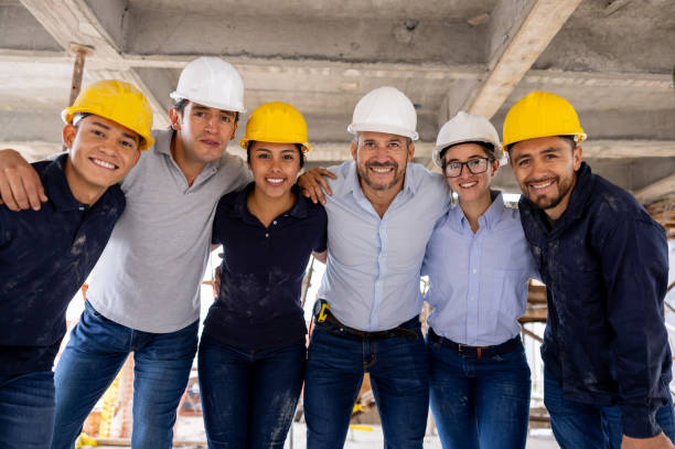 istock Team of construction workers looking happy at a building site 2159239802
