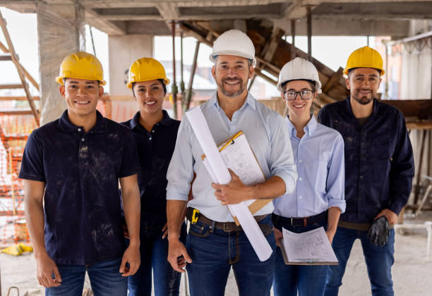 istock Group of construction workers smiling at a building site 2159239812