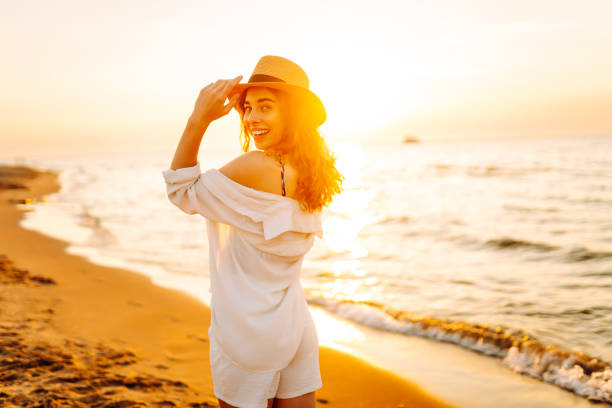 istock Happy woman walking at a beach at sunset. 2159240813