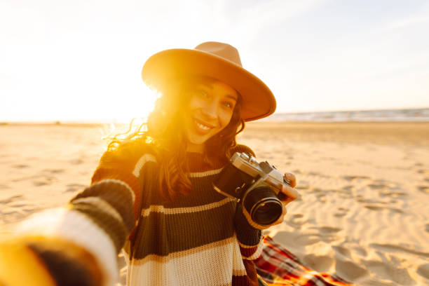 istock Happy woman makes self-portraits on spring sandy beach background at sunset. 2159243931