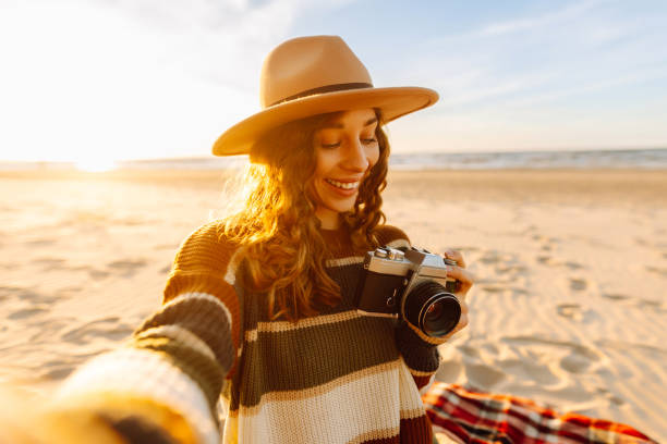 istock Happy woman makes self-portraits on spring sandy beach background at sunset. 2159243939