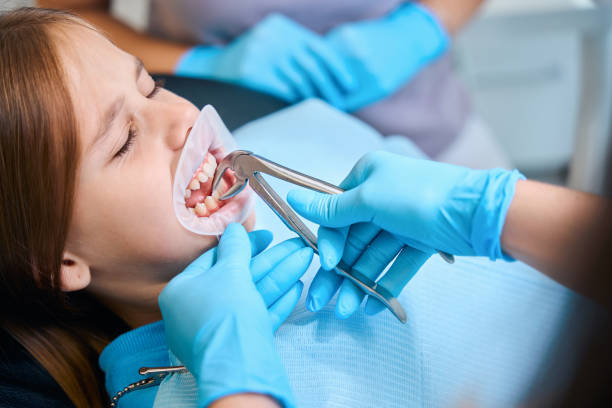 istock Dentist removes a girl tooth with a special tool 2159249222