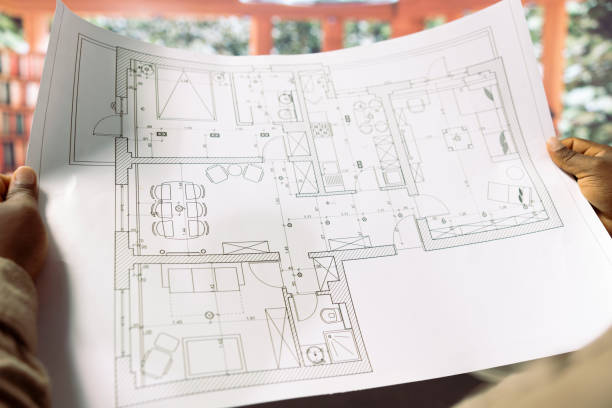 Professional businessman reviewing architectural blueprints for new office hunt
