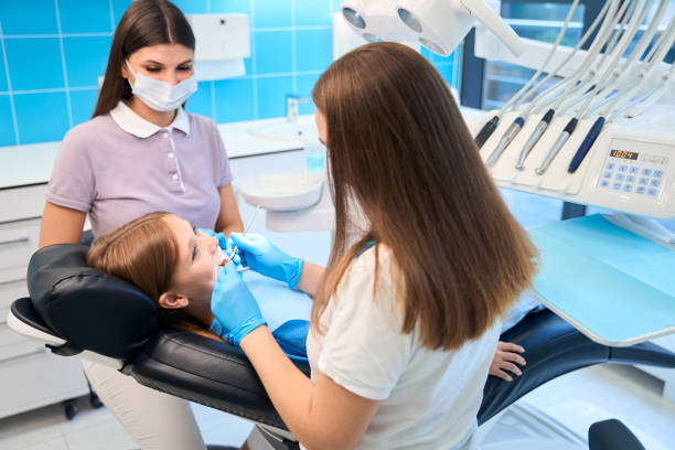istock Dentist begins to examine the girls teeth 2159253055