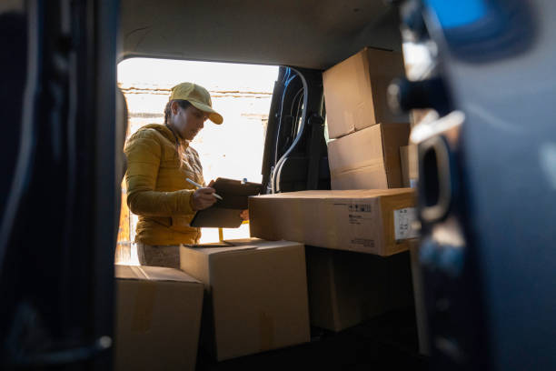 istock Gig Workers. Female Delivery Driver Checks Parcels for Delivery. 2159261177