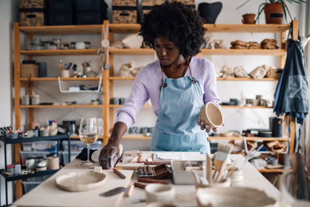 istock Diverse craftswoman with clay work in hands standing at pottery studio 2159261479