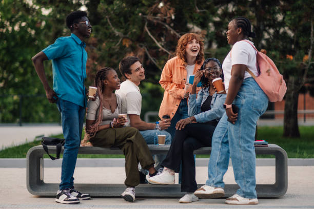 istock Cheerful diverse group of college students talking and smiling at campus 2159261540