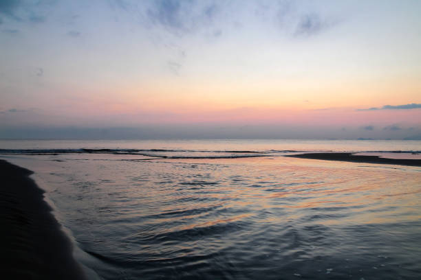 Sunrise by the sea with calm waves