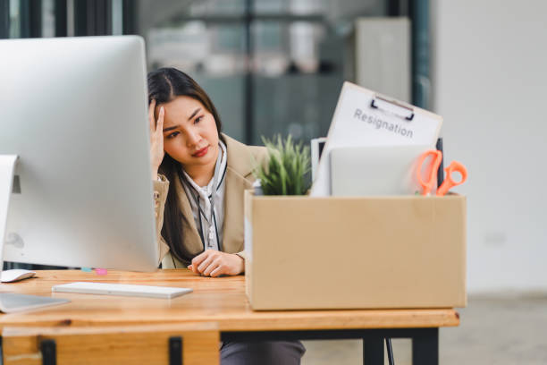 istock Stressed Employee with Resignation Box at Desk. 2159268102
