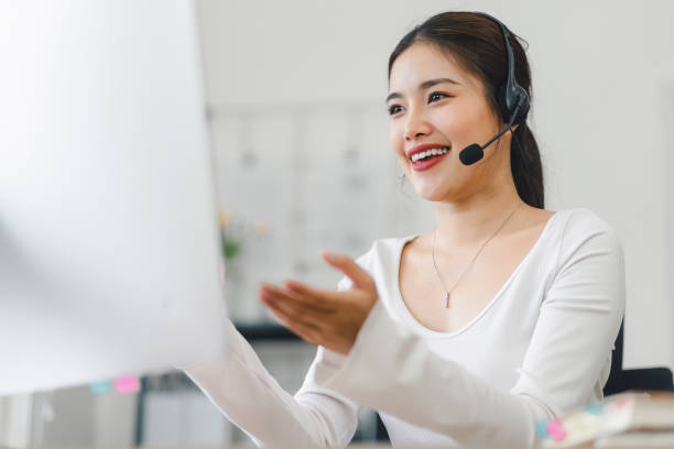 istock Smiling woman wearing headset, participating in video conference call from home office, using computer for virtual communication. Soft focus 2159268186
