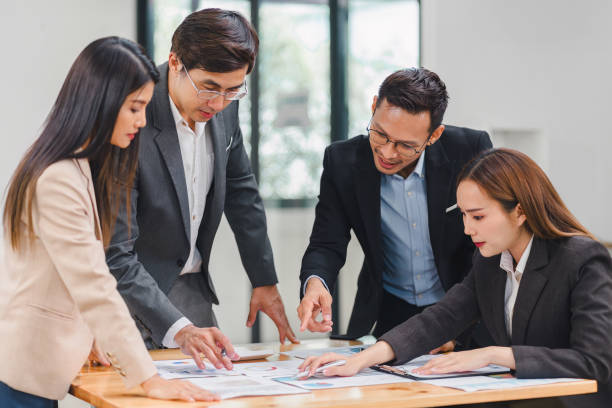 istock Diverse business team analyzing data and discussing strategies during an office meeting, using documents and a laptop. 2159268587