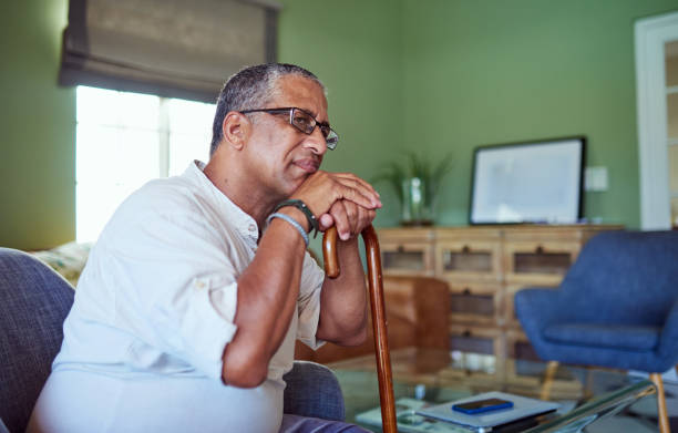 istock Old man, thinking and on sofa in home with cane, focus or contemplating retirement, life or memory. Senior, retired and disabled male from India sad, lost in thoughts and sitting alone in house. 2159278721