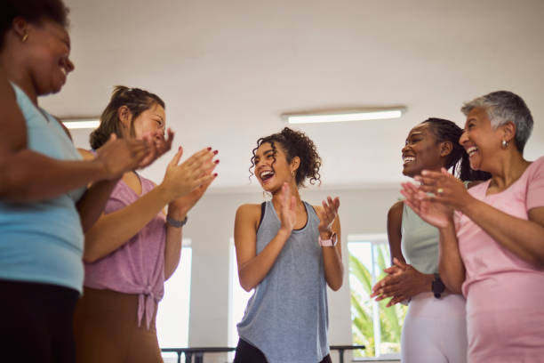 istock Low angle view of  female coach laughing with multiethnic students and clapping hands after class in studio 2159278923