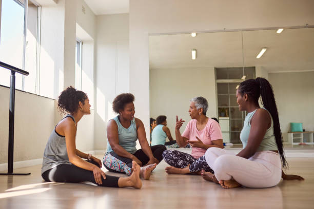istock Group of multiethnic students of different ages sitting on floor, sharing experiences in exercise class 2159278930