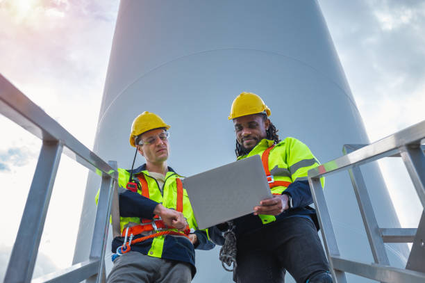 istock Two men wearing safety gear and holding a laptop 2159286245