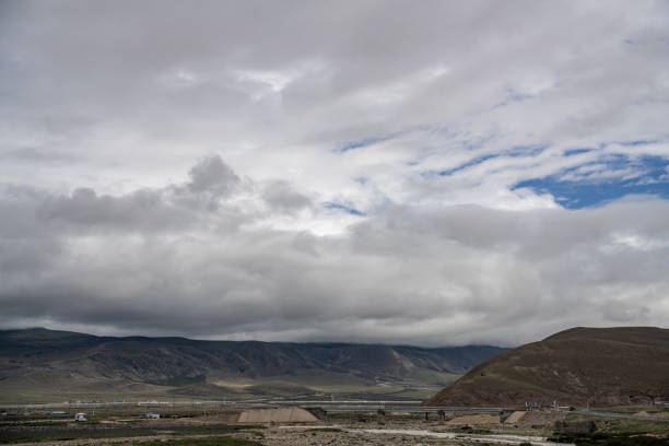 Cloudy weather, mountains and green fields on the plateau