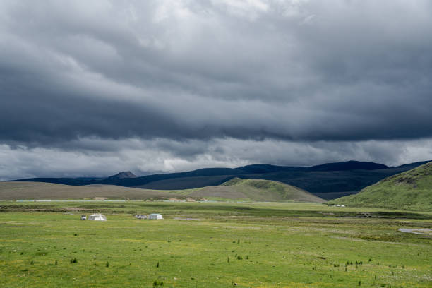 Cloudy sky, mountains on the plateau, green land