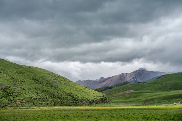 Cloudy sky, mountains on the plateau, green land