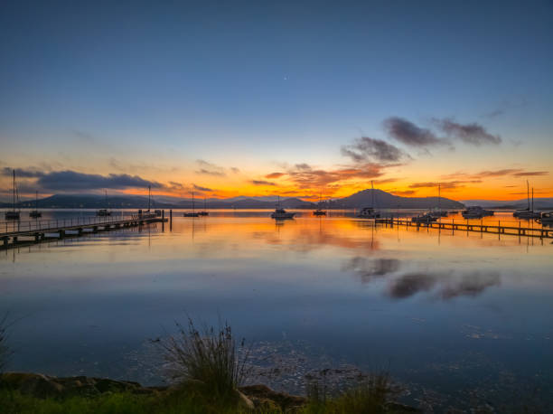 istock Sunrise over the calm water with boats and reflections 2159292855