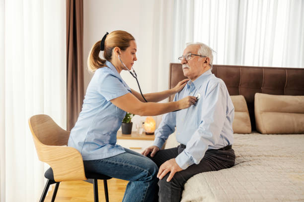 istock A doctor is examining senior man's lungs during her home visit. 2159294054