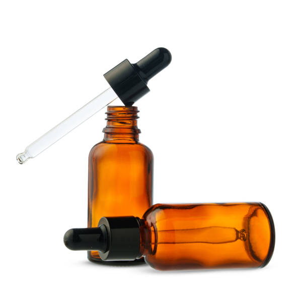 istock Two Amber Glass Dropper Bottles With One Dropper Removed on White Background 2159294522