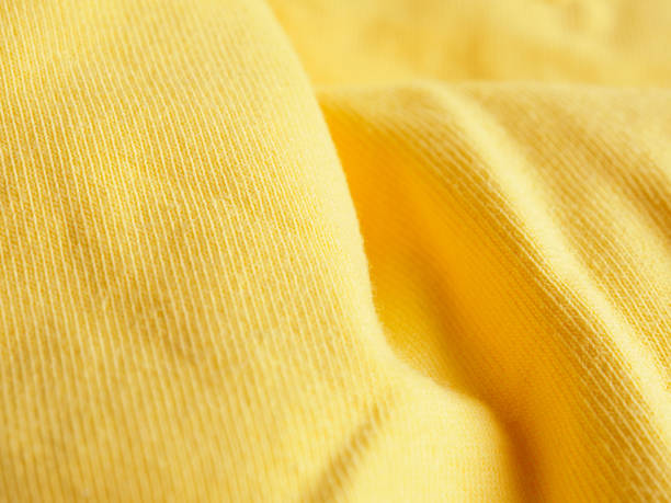 istock Stitched seam on yellow fabric textile background close-up 2159294827