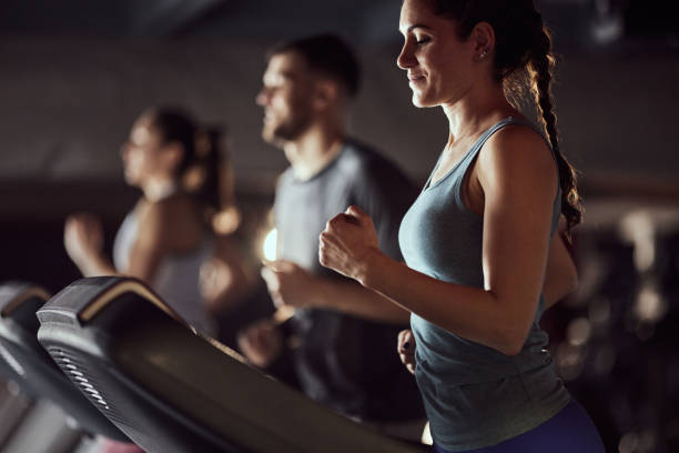 istock Smiling athletic woman warming up on treadmill in a gym. 2159296975