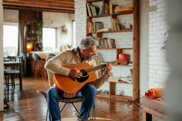 istock Mature man playing guitar in living room 2159298127