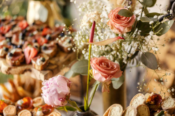istock Close up of pink rustic roses on wedding table with appetizer in background. 2159298448