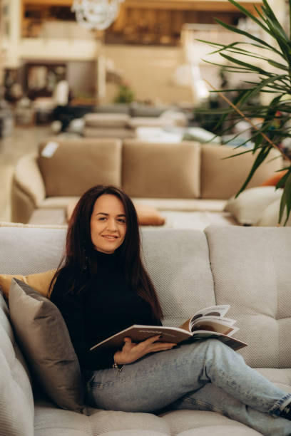 istock A woman looks through a catalog in a sofa store 2159298621