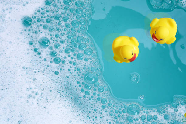 istock Yellow rubber ducks in water with soap foam 2159298920