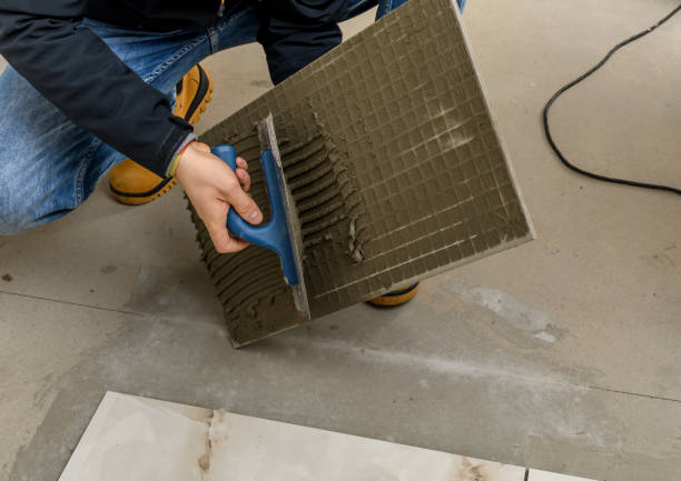 istock Finishing work, a man at work is laying the floor, smearing the tile with tile glue 2159300420