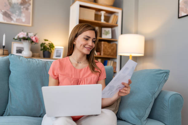 istock Nice beautiful woman work on laptop notebook sit down on the sofa at home - check on analytics - technology woman concept for alternative office freelance 2159302544