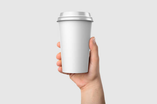 istock Paper coffee cup with plastic cap in a hand mockup template, isolated on light grey background. 2159307649
