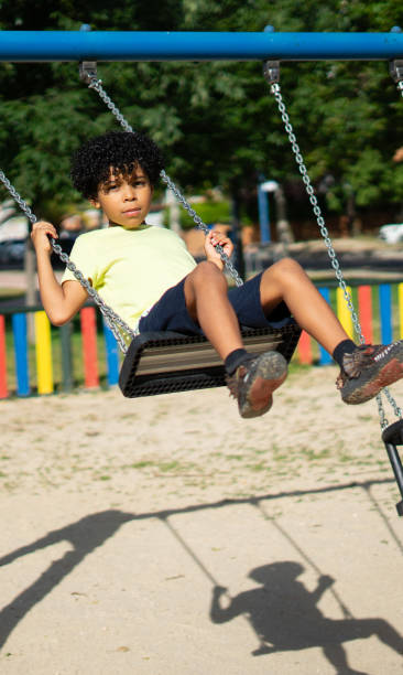 istock Latino boy swinging on a playground swing 2159307975