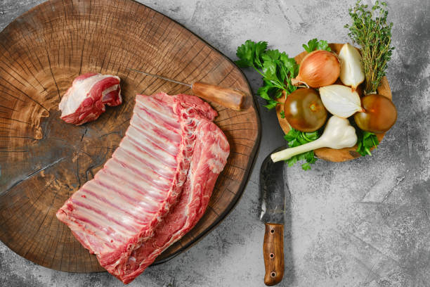 istock Raw fresh lamb ribs on wooden slab, top view 2159309019