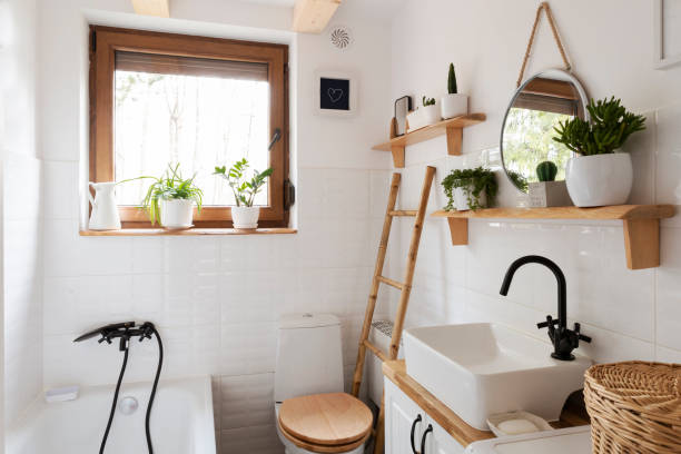 Home interior with ceramic bathroom sink and white tile on the wall with circle mirror. Rustic bathroom with window in indoors architecture and cosy design in cottage.