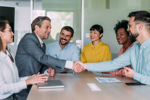 istock Businessmen shaking hands across the table. 2159311906