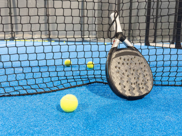 istock professional paddle tennis racket with natural lighting on blue background. Horizontal sport theme poster, greeting cards, headers, website and app 2159314868
