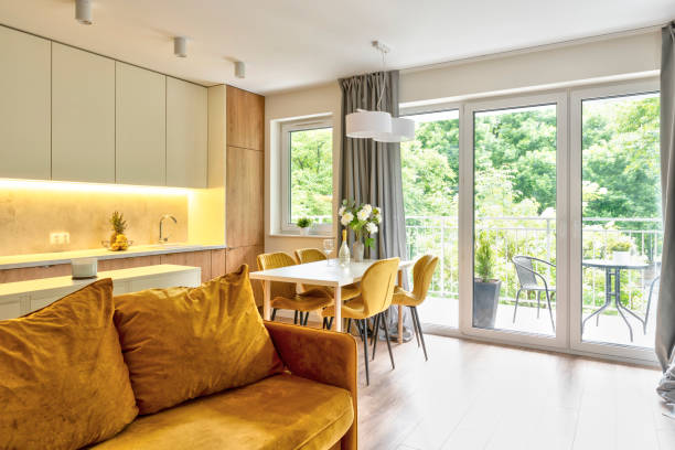 istock Interior decor of living room with window, comfortable mustrad sofa and kitchen. 2159314984