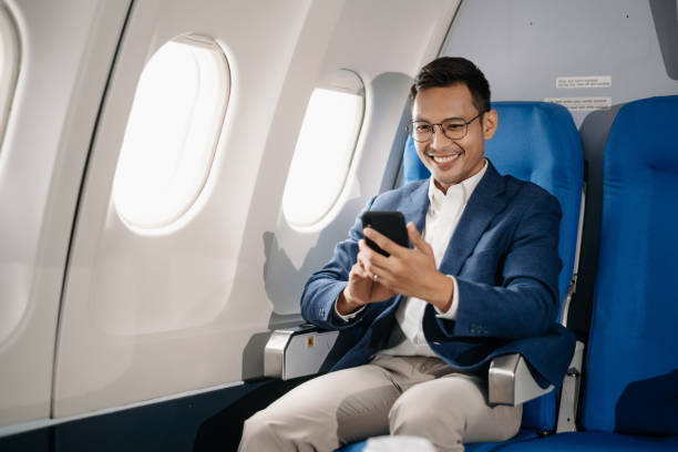 istock Young Asian executive excels in first class, multitasking with digital tablet, laptop and smartphone. Travel in style, 2159315199
